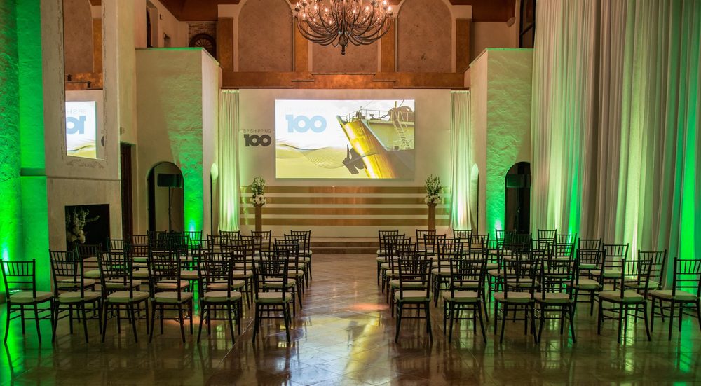 Theater-style seating facing a presentation stage with projection screen at The Bell Tower on 34th, Houston, TX.